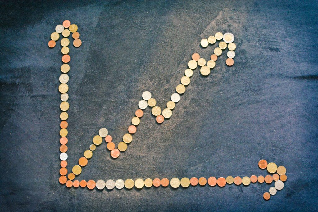 Graph made out of coins with an arrow as the axis, and an upward trend arrow.